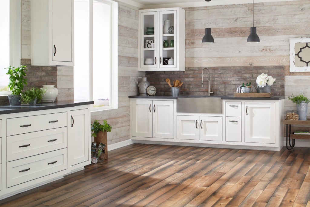A farmhouse style kitchen with birch hardwood floors and gray quartz countertops. 