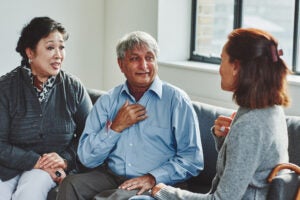 Female carer treating senior couple retirement home