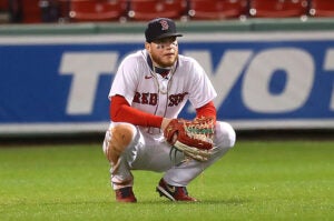 Alex Verdugo sqautting in the outfield at Fenway
