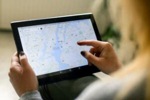 Unrecognizable Caucasian woman using the Google Maps app on a Lenovo tablet, looking at a map of New York.