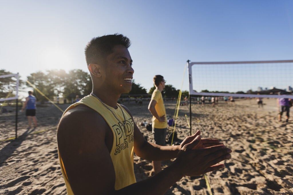 An athlete claps for his teammates during a friendly game of beach volleyball. 