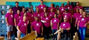 A group of people wearing pink VMware shirts smile at the camera.