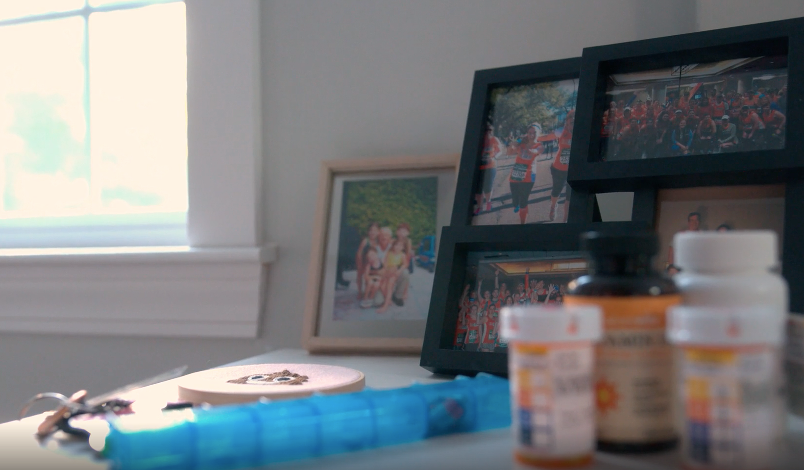 Pill bottles and a daily pill organizer sit in front of photographs.