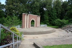 Wide view of an amphitheater stage surrounded by trees.