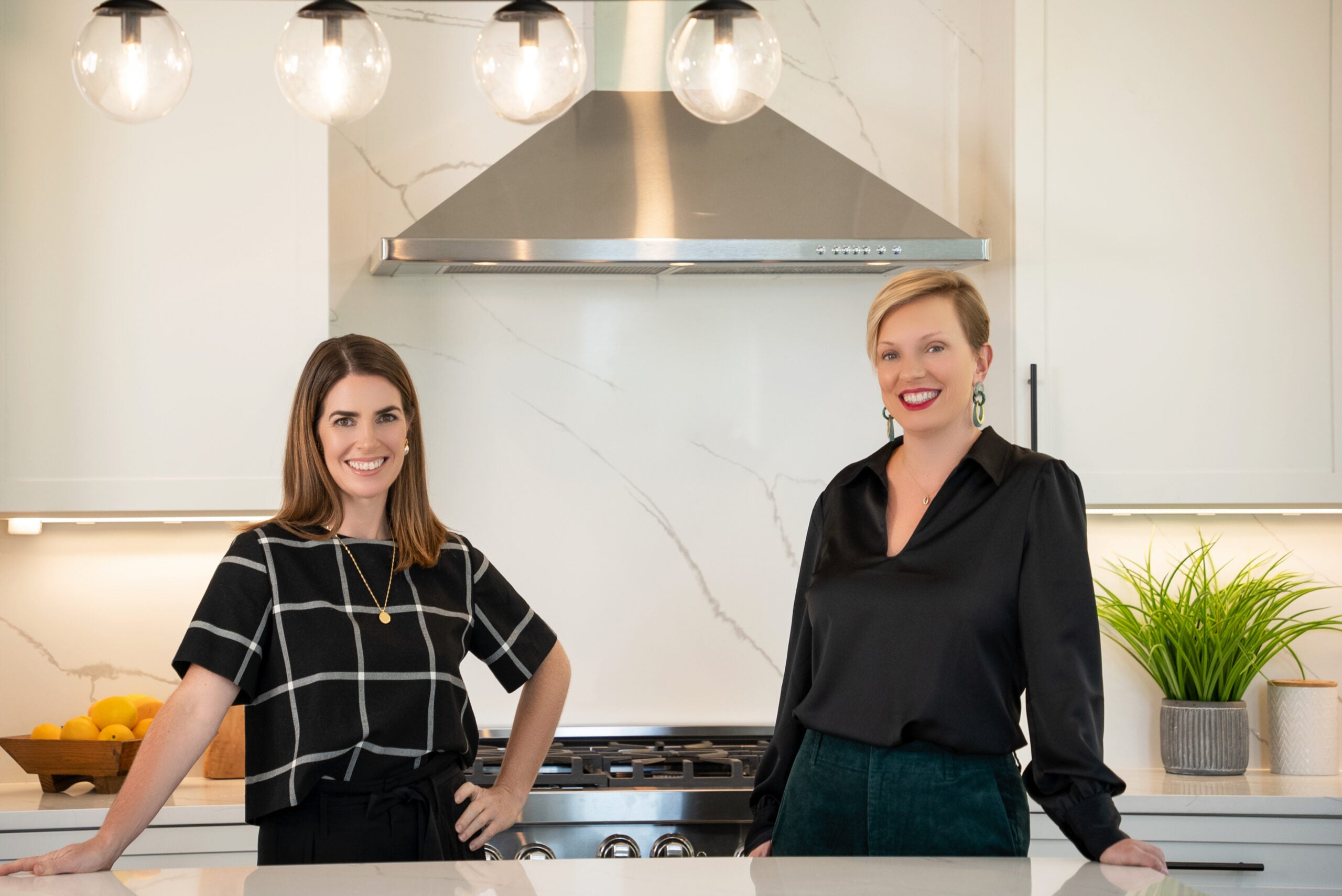 Beth Maguire and Meredith Smith smile in large, modern kitchen