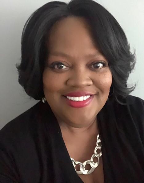 Kimberly Richardson's Headshot: Middle-aged black woman with short black bob, statement necklace and red lipstick
