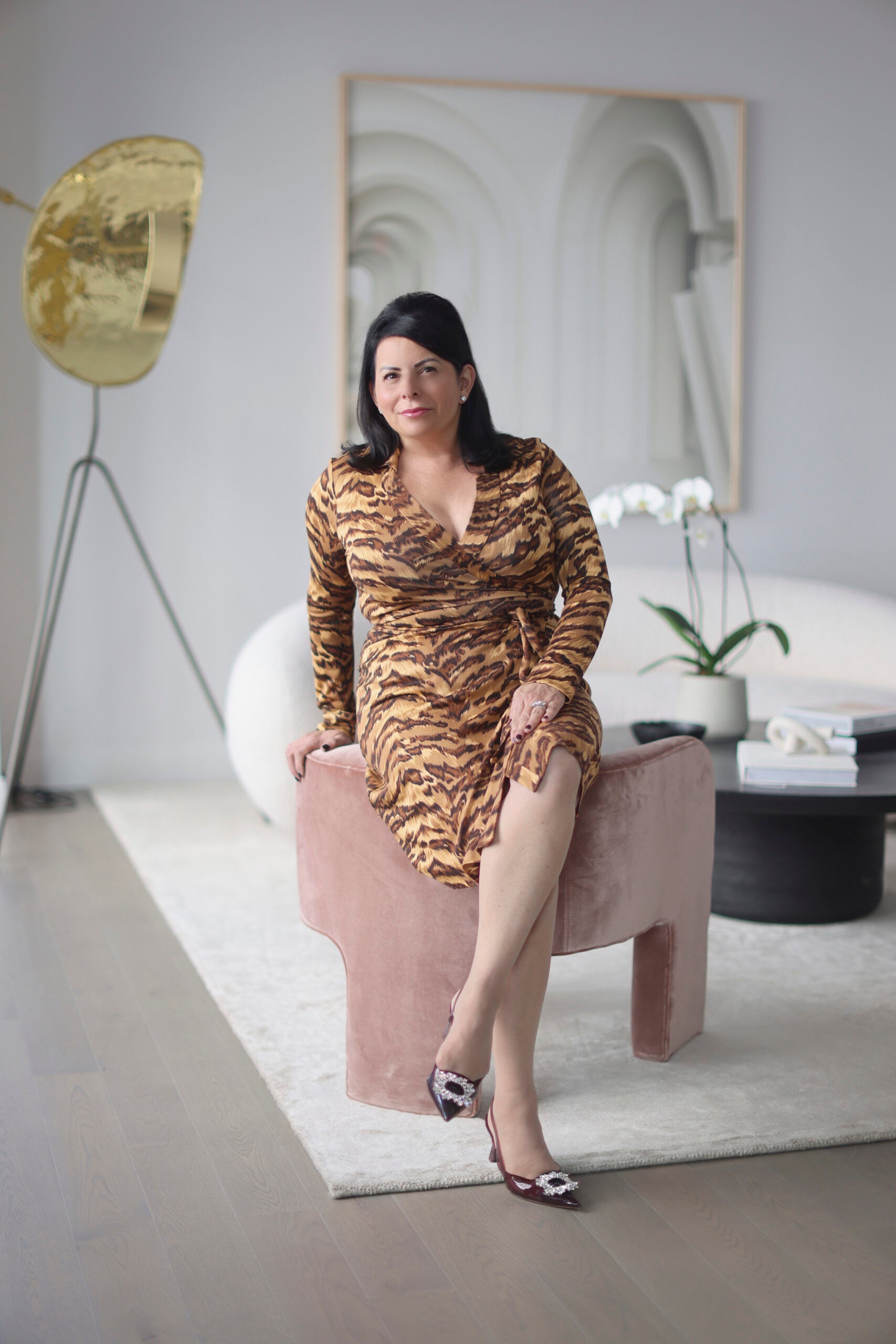 Lisa Rainis in a living room wearing tiger print dress