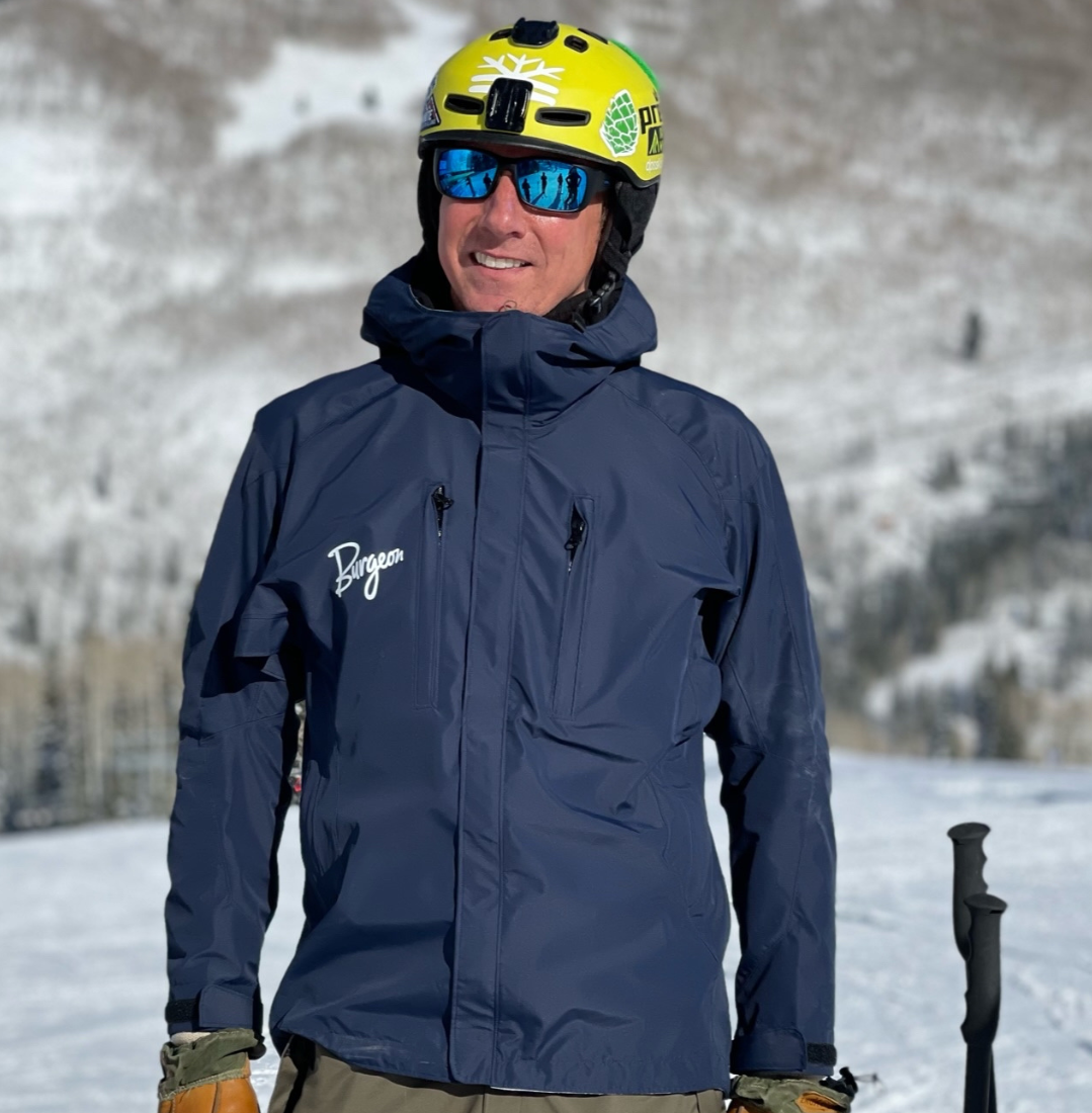 Man on snowy mountain wearing navy down jacket