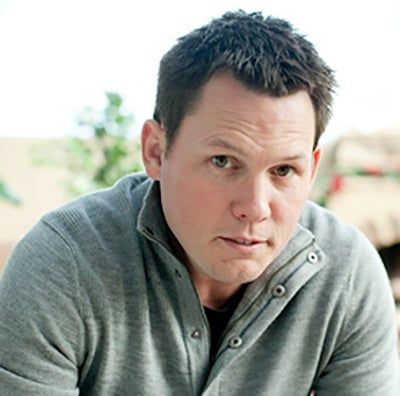 Headshot of Ronnie Sharpe: Middle-aged man with brown hair and dark eyes wearing a grey polo shirt.  