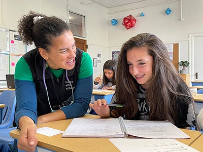 A teacher helping a student with an assignment during class.