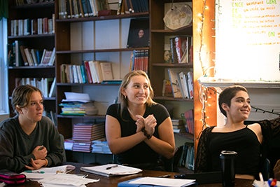 Three students participating in discussion in classroom. 