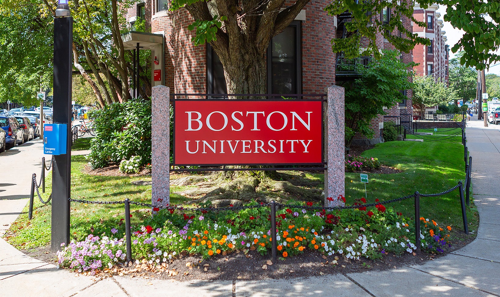 A red sign that says "Boston University" stands outside a university building.