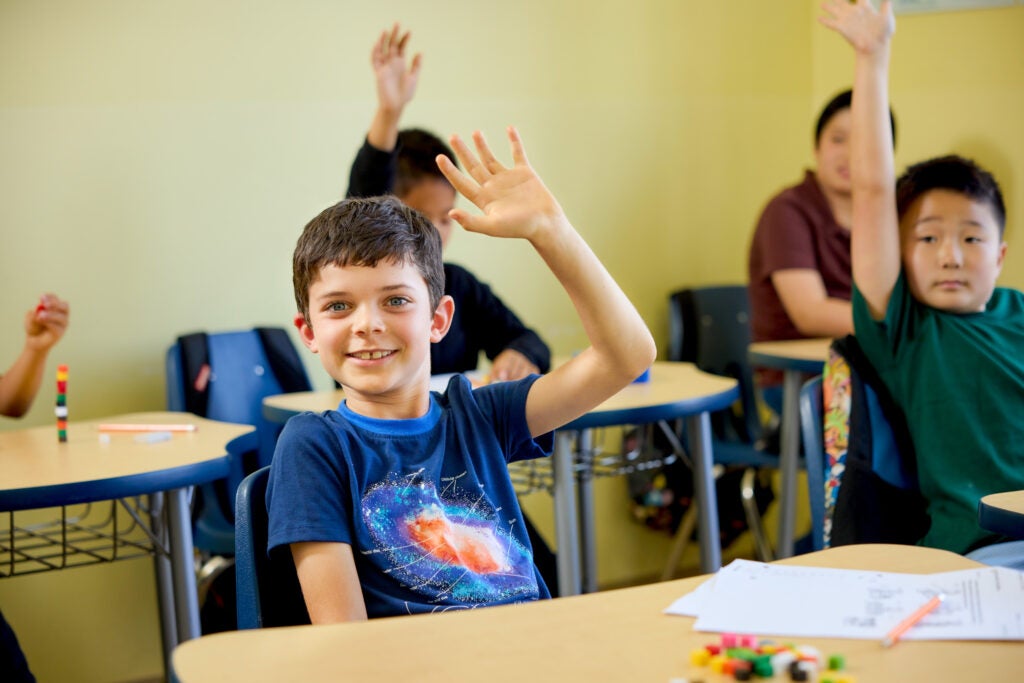 Group of children raising their hands 
