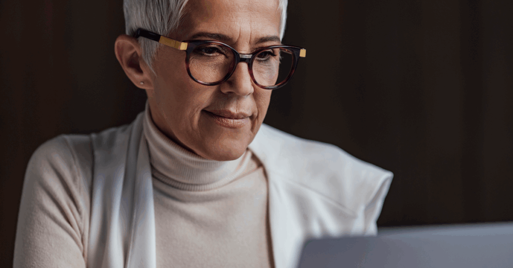Woman wearing glasses working on her computer. 