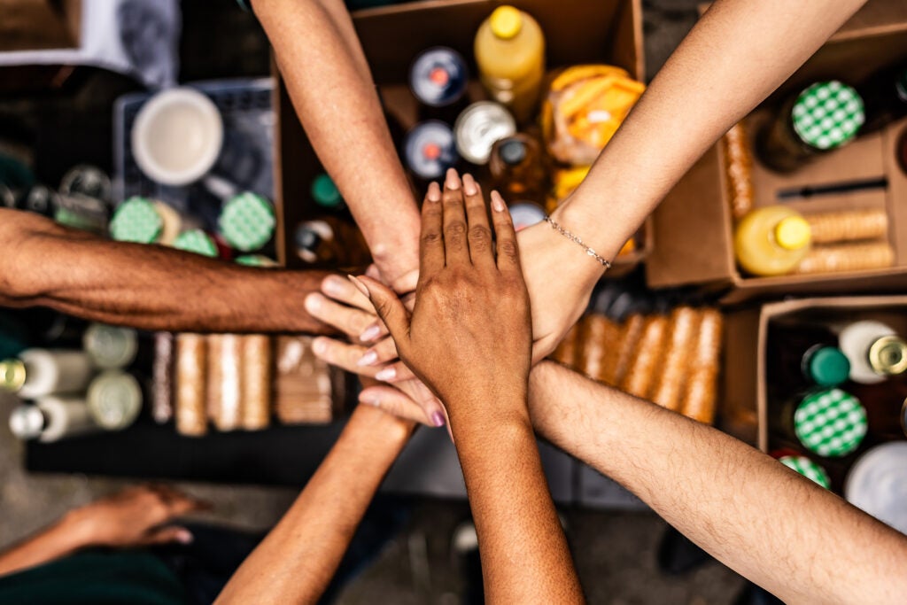 People stacking hands over donation boxes