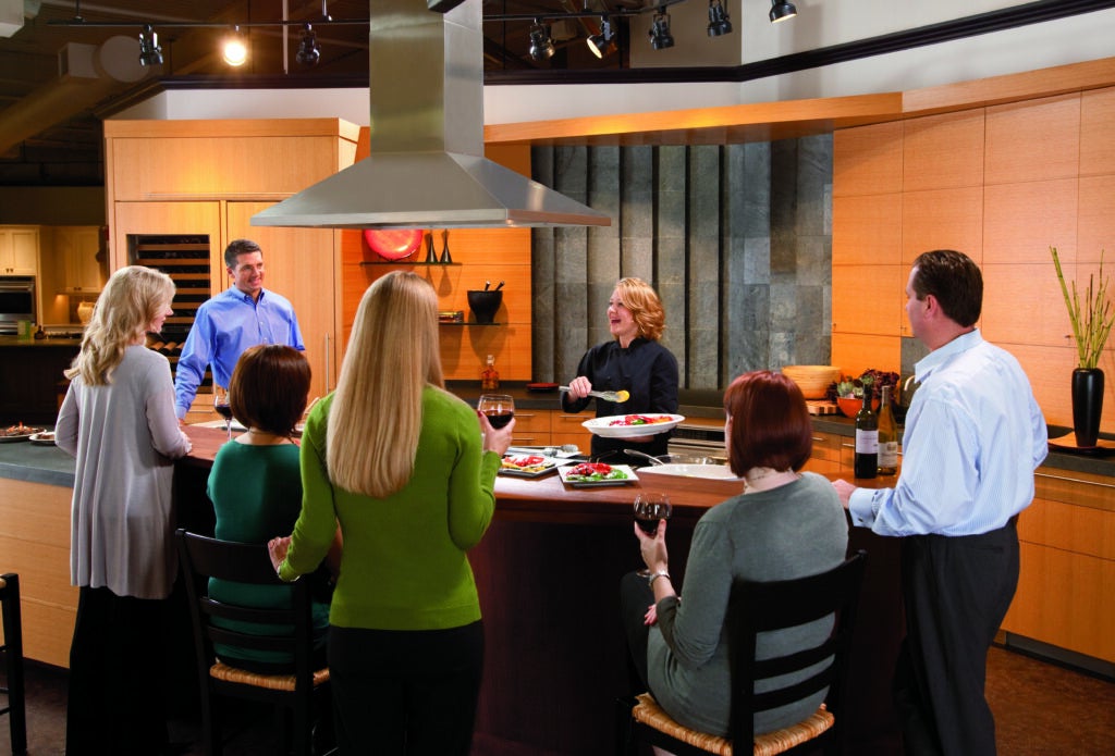 Customers seated around a kitchen table with a Clarke chef 