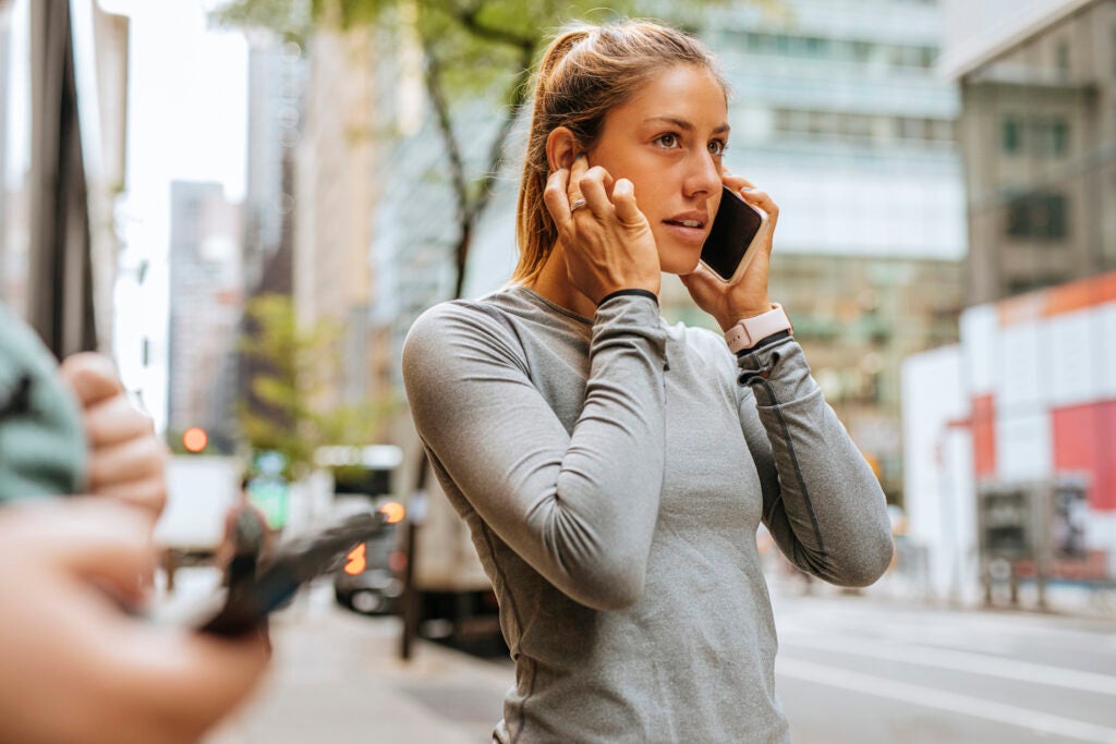 Woman on a phone call blocking her right ear with her right hand