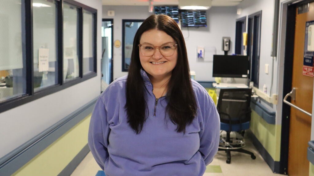 Profile of a nurse wearing a purple quarter zip