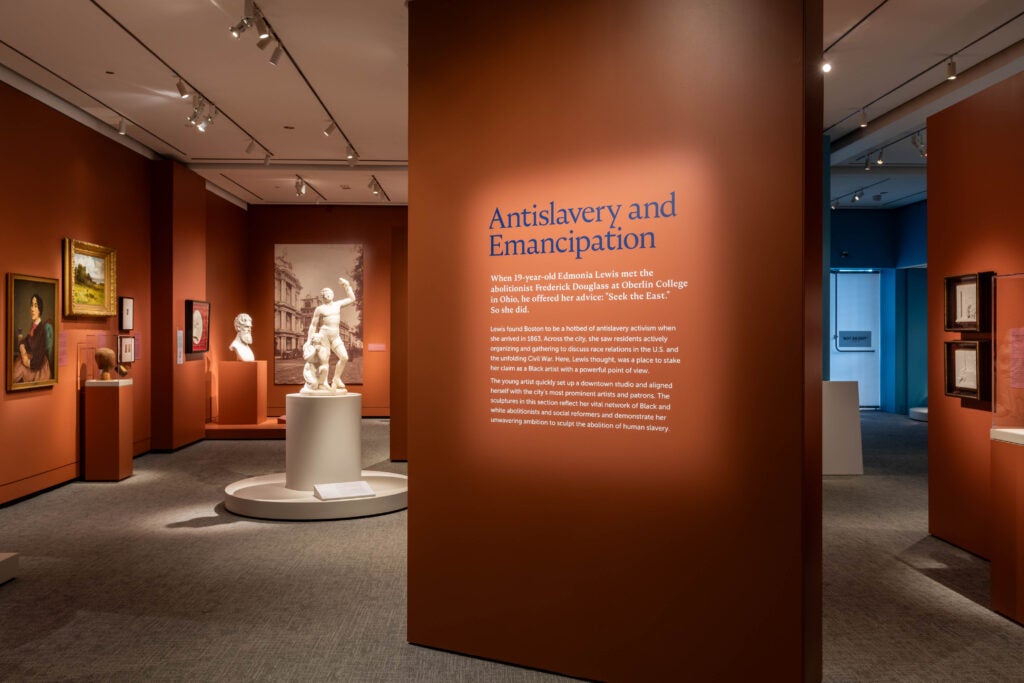 Hall inside the Peabody Essex Museum displaying different sculptures, paintings, and busts 