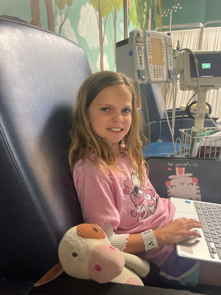 Kathleen's daughter, Emma, sitting in the exam room with her computer