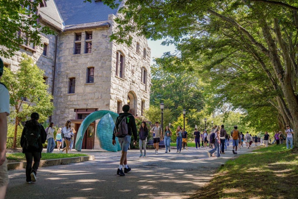Students of the University of Rhode Island walking towards a school building 
