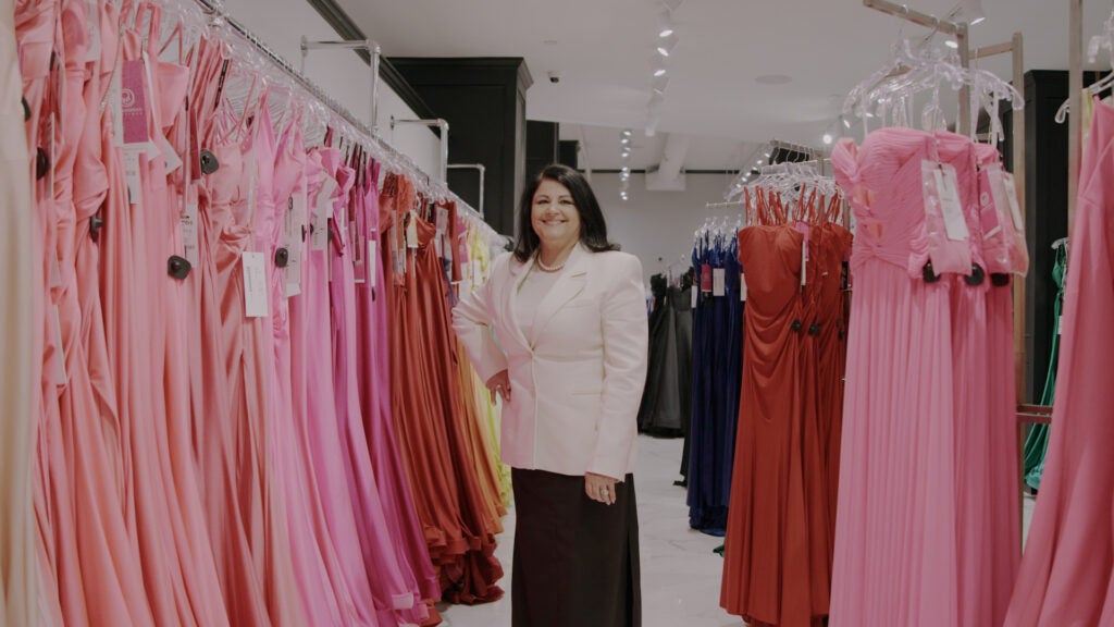 Fatima Benson posing alongside pink dresses in one of the store's sections. 