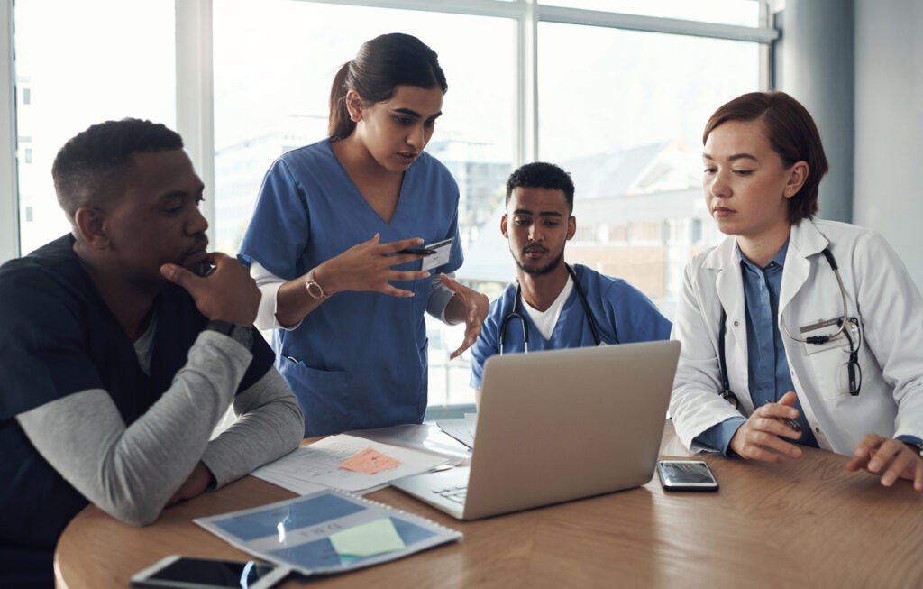 Nurses gathered around a round table discussing 