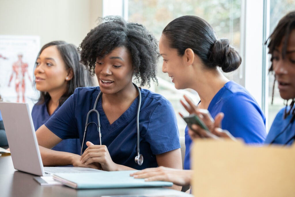 Nurses sitting down in a classroom working with their computers